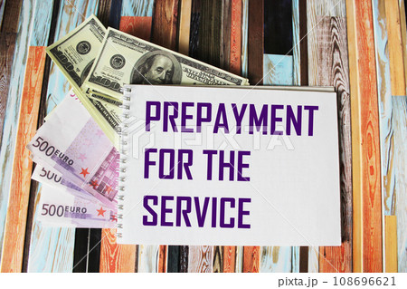 text PREPAYMENT PAYMENT FOR SERVICE on a laptop, next to euro and dollar bills 108696621
