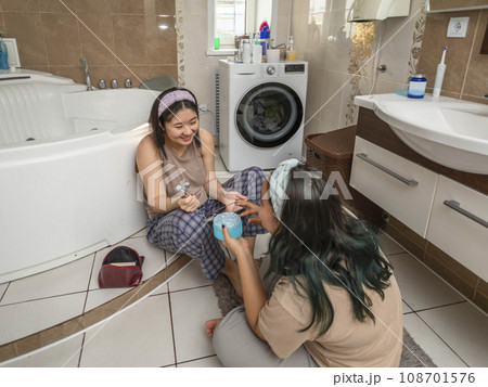 Asian laughing beauties begin their morning routine with acne treatment and facial massage in the bathroom Asian laughing beauties begin their morning routine with acne treatment and facial massage in the bathroom 108701576