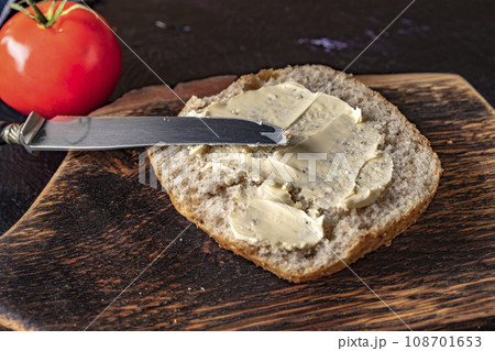 Slice of bread smeared with butter. 108701653