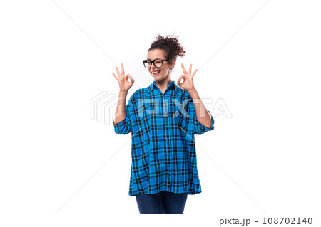 portrait of a slender young pretty woman with curled hair in a blue shirt 108702140