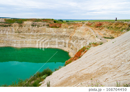 Lake formation in an old abandoned quarry. Quarry lake. Termination of mining operations. 108704450