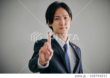 白バックを背景に人差し指を立てる男性弁護士 108704815