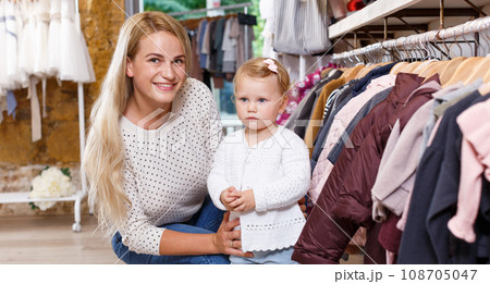 Woman and daughter buying kids clothes Woman and daughter buying kids clothes 108705047