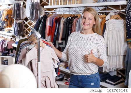 Girl choosing kids clothes in boutique Girl choosing kids clothes in boutique 108705148