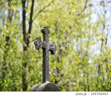 Stone cross on the grave Stone cross on the grave 108706403