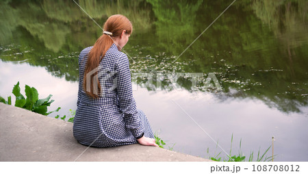Pretty girl sitting at the lake Pretty girl sitting at the lake 108708012
