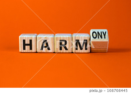 From harm to harmony. Turned a wooden cube and changed word harm to harmony. Beautiful orange table, orange background. Business and harm or harmony concept. Copy space. From harm to harmony. Turned a wooden cube and changed word harm to harmony. Beautiful orange table, orange background. Business and harm or harmony concept. Copy space. 108708445