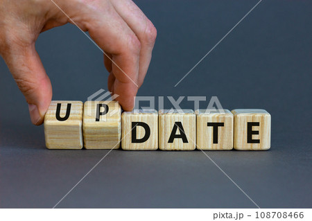 Date or update symbol. Businessman turns wooden cubes and changes the concept word date to update. Beautiful grey table, grey background, copy space. Business and date or update concept. 108708466
