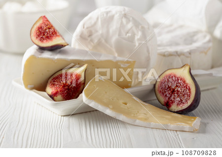 Camembert cheese with figs on a white table. 108709828