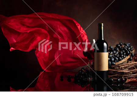 Red wine with grapes on a background of red flutters curtain. 108709915
