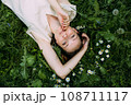 Beautiful woman with natural beauty without makeup lies in the grass in summer 108711117
