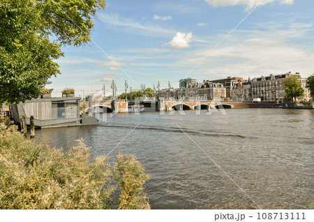a river with boats and buildings in the background, taken from a boat on the water's edge as it is moving through a river with boats and buildings in the background, taken from a boat on the water's edge as it is moving through 108713111