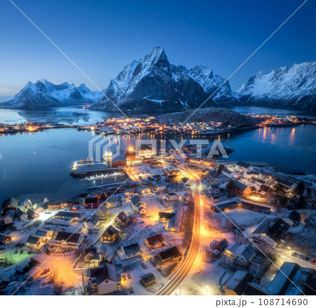 Aerial view of snowy village, city lights, sea, mountain at night Aerial view of snowy village, city lights, sea, mountain at night 108714690