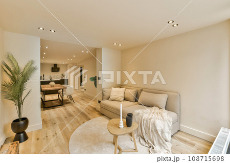 a living room with a couch, coffee table, and television in the corner on the wall is painted white 108715698