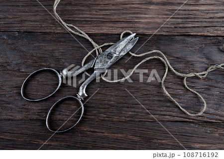 Antique old vintage retro scissors with thread on wooden table. 108716192
