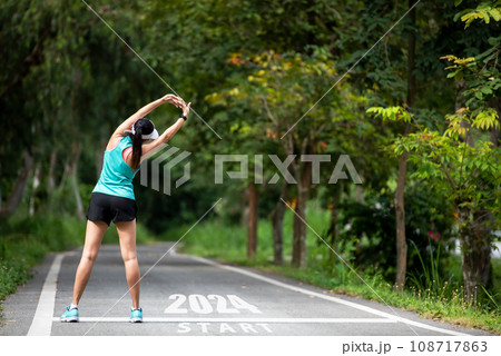 The start into the new year 2024. Start up of runner woman running on nature race track go to Goal The start into the new year 2024. Start up of runner woman running on nature race track go to Goal 108717863