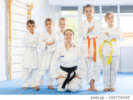 Portrait of female karate or judo coach with her students little children in gym 108718489