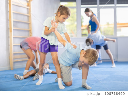 Children, boy and girl, working in pair mastering new self-defense moves at gym 108718490