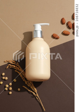 Blank label pump bottle decorated with soybeans and almonds. Beige and brown background. Concept of natural ingredients for branding mockup design 108718832
