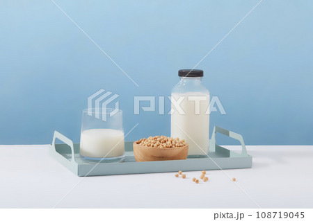 Empty label milk bottle arranged on a tray in pastel color with a cup of milk and wooden bowl of soybeans. Template for mockup your design Empty label milk bottle arranged on a tray in pastel color with a cup of milk and wooden bowl of soybeans. Template for mockup your design 108719045