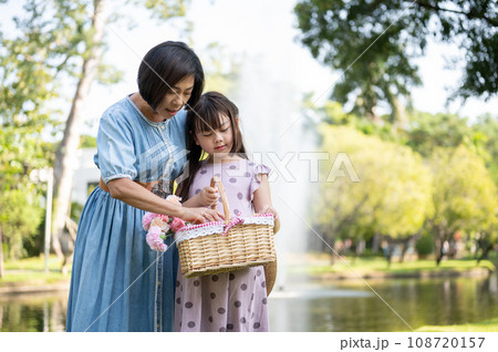 Happy and kind Asian grandmother is walking and having fun in the park with her lovely granddaughter Happy and kind Asian grandmother is walking and having fun in the park with her lovely granddaughter 108720157