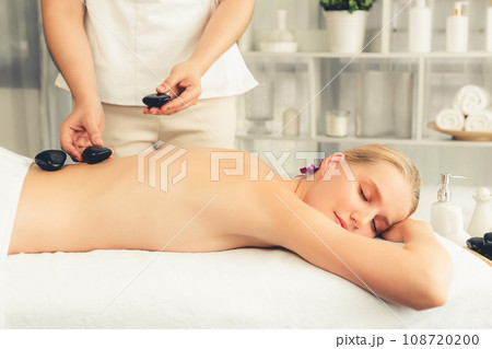 Hot stone massage at spa salon in luxury resort. Quiescent 108720200