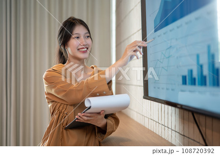 A smart Asian businesswoman is presenting her financial analysis information in the meeting. A smart Asian businesswoman is presenting her financial analysis information in the meeting. 108720392