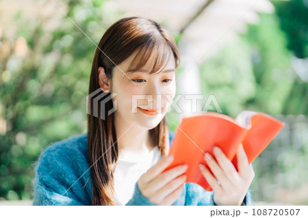 テラスで読書をする若い女性 108720507