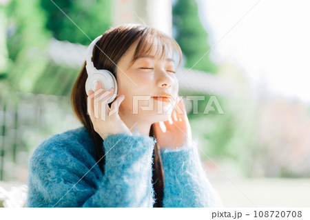 テラスで音楽を聴く若い女性 108720708