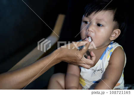Mother Feeding Her Son With Rice. Mother Is Feeding Her Son. Concept of loss of appetite. Kid with no appetite. Mother Feeding Her Son With Rice. Mother Is Feeding Her Son. Concept of loss of appetite. Kid with no appetite. 108721165