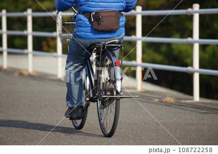 秋の朝の公園の道で自転車を乗っているシニア男性の姿 108722258