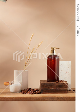 Beige wall background with pump bottle on wooden podium, coffee beans and bath salt on wooden pedestal. Empty label for design. Mockup for design, organic cosmetics, beauty products concept 108722625