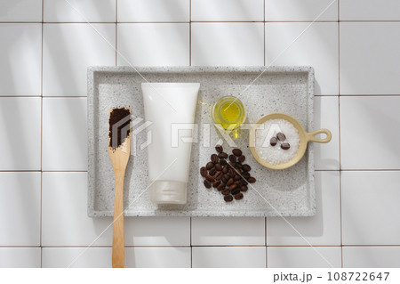 On white tile background, a gray marble tray container coffee beans, coffee powder, bath salt and cosmetics tube. Mockup scene for advertising organic cosmetic for skin care with coffee ingredient On white tile background, a gray marble tray container coffee beans, coffee powder, bath salt and cosmetics tube. Mockup scene for advertising organic cosmetic for skin care with coffee ingredient 108722647