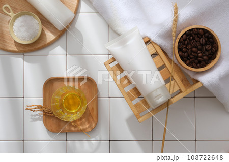 Bathroom concept for advertising cosmetic product for skincare and body care with natural ingredient. A white plastic tube displayed on wooden tray with bath object on white tile background 108722648