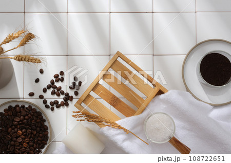 Abstract background for branding and minimal presentation with natural ingredient. Coffee beans, bath salt and wheat decorated with bath object on white tiles background. Space for design Abstract background for branding and minimal presentation with natural ingredient. Coffee beans, bath salt and wheat decorated with bath object on white tiles background. Space for design 108722651