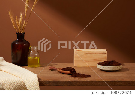 Front view of wooden pedestal for product presentation with coffee powder decorated. Vintage brown background with blank space for display mockup bottle. Concept for organic product 108722674
