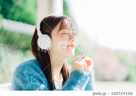 テラスで音楽を聴く若い女性 テラスで音楽を聴く若い女性 108724108