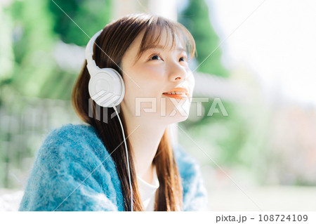 テラスで音楽を聴く若い女性 108724109