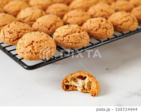 Amaretti cookie on cooling rack - traditional Italian Sardinian pastry. Delicious amaretti biscuit cookies made from almond or apricot kernels with copy space Amaretti cookie on cooling rack - traditional Italian Sardinian pastry. Delicious amaretti biscuit cookies made from almond or apricot kernels with copy space 108724944