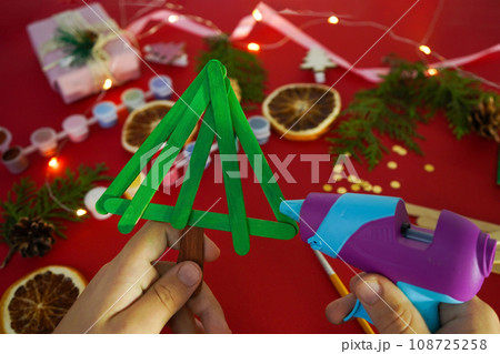 Step by step instruction how to make christmas tree from ice cream sticks. Step 3 glue sticks together. Children's New year handmade craft 108725258