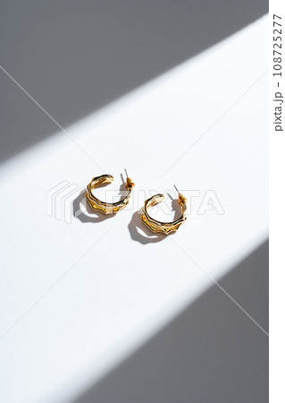 Golden earrings on white background studio shot 108725277