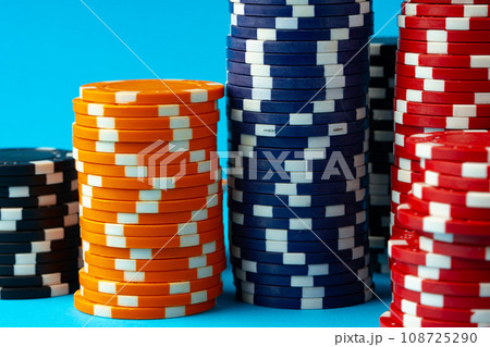 Stacks of poker chips on blue background Stacks of poker chips on blue background 108725290