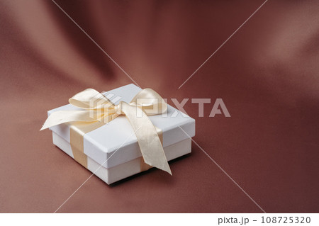 White jewelry boxes on brown silk background 108725320