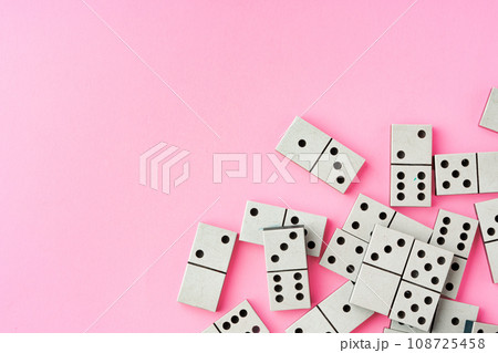 Domino tiles on pink background studio shot Domino tiles on pink background studio shot 108725458