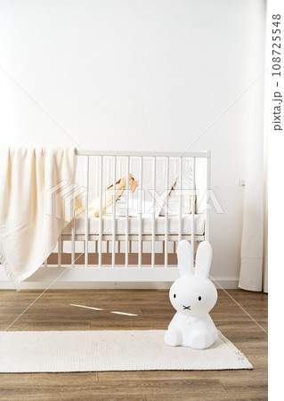 Baby wooden crib and toy rabbit in nursery room Baby wooden crib and toy rabbit in nursery room 108725548