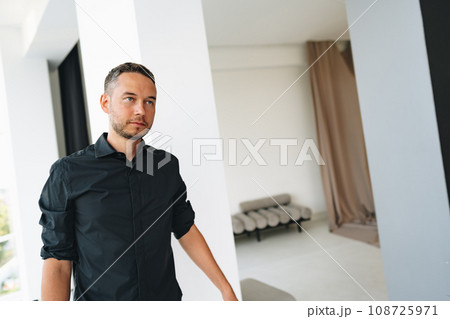 Portrait of a man in black shirt posing in photostudio 108725971
