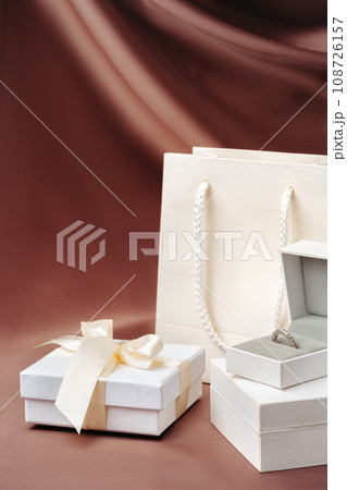 White jewelry boxes on brown silk background White jewelry boxes on brown silk background 108726157