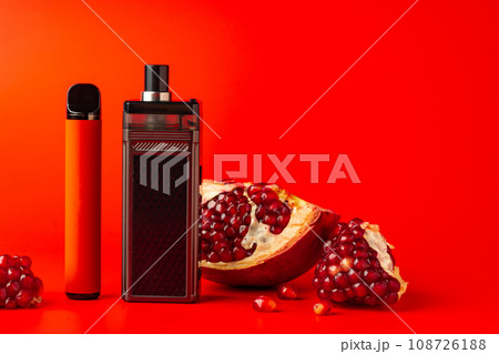 Electronic cigarette with pomegranate flavor on red background 108726188