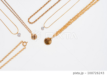 Set of gold chains with pendant on white background Set of gold chains with pendant on white background 108726243