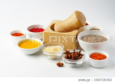 Wooden mortar with spices on white background Wooden mortar with spices on white background 108726302